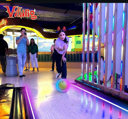 People playing a game with colorful lights and a 'Viking' sign in the background
